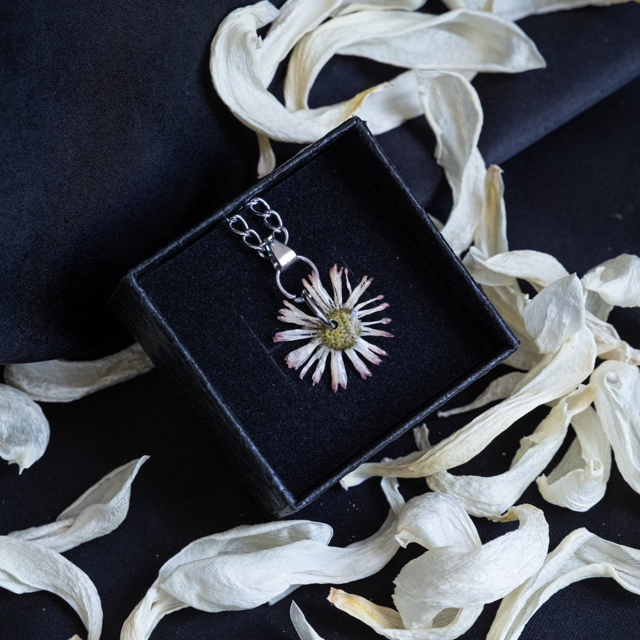 Pendentif artisanal orné d'une fleur séchée, inclus dans la Box Litha YourCult pour célébrer la lumière et la beauté du Solstice d'été.